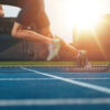 Athlete runner feet running on treadmill closeup on shoe - Track and field runner in sport uniform at starting position - Fitness lifestyle, sport and healthy concept